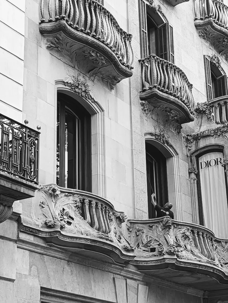 Man cleaning balcony window in old building