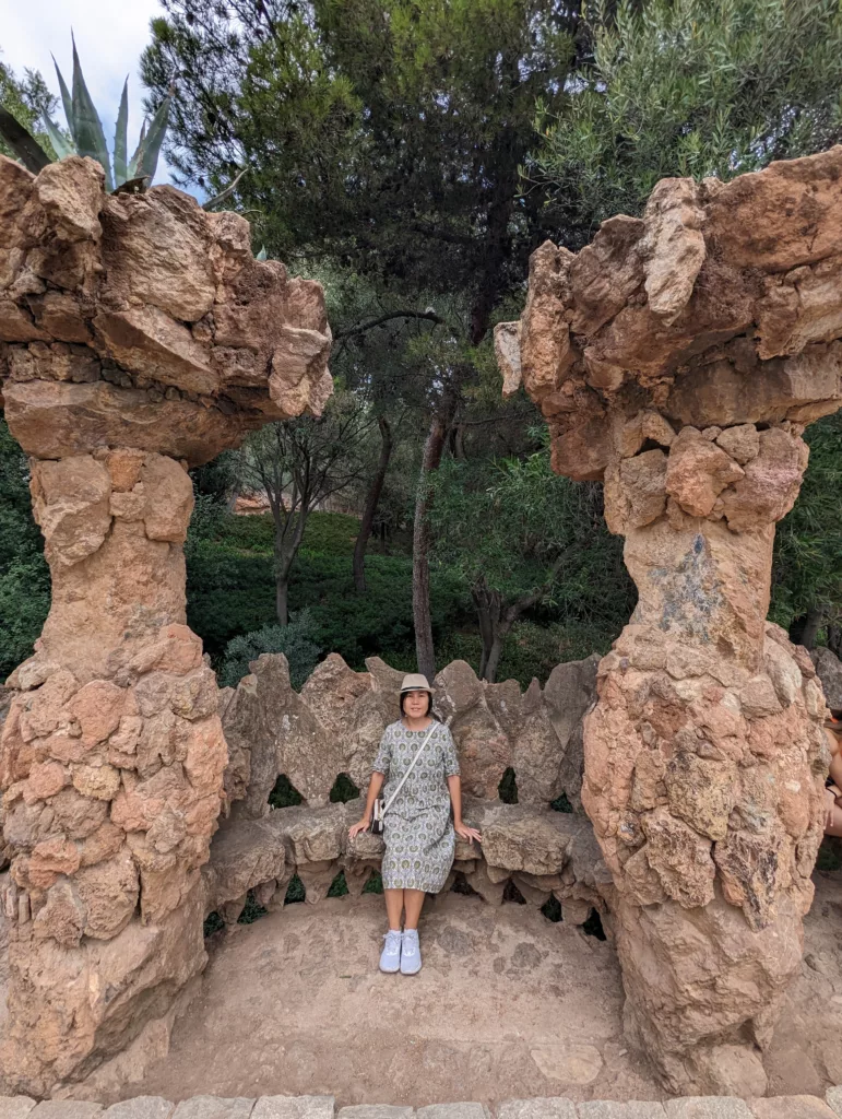 Sachie sitting on a stone bench between columns