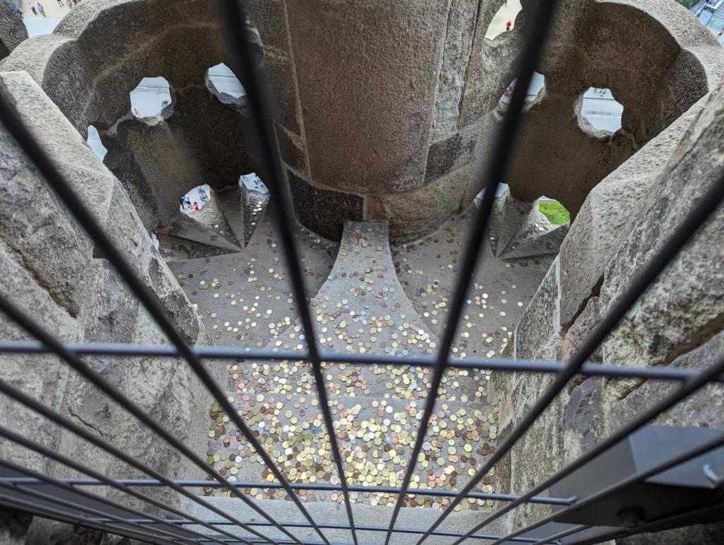 View of tower balcony behind bars with many coins
