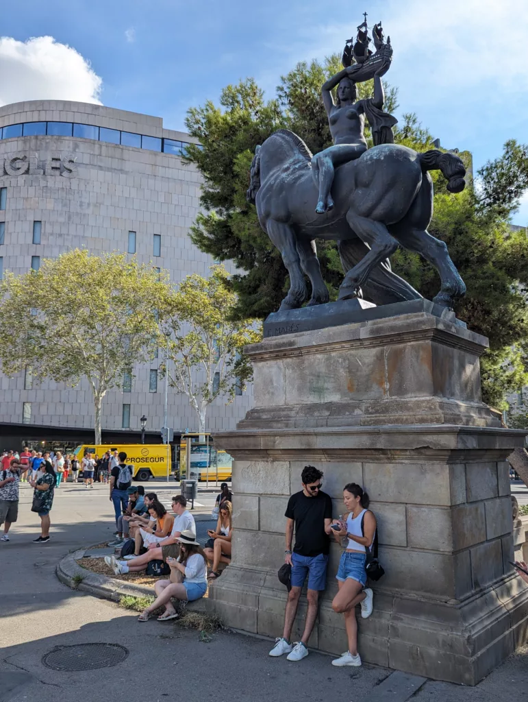 Tourists standing under statue