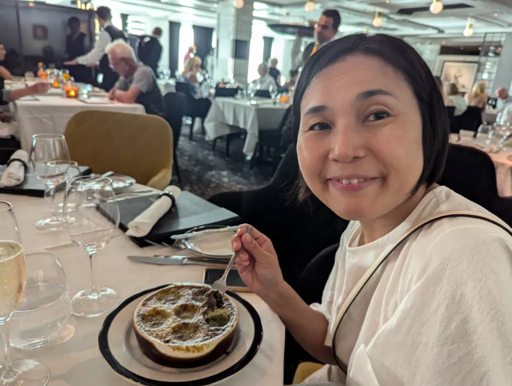 Sachie eating snails in restaurant.